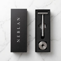 Coffret Neblan ouvert : rasoir de sûreté, support en acier et étui de 10 lames dans la mousse noire